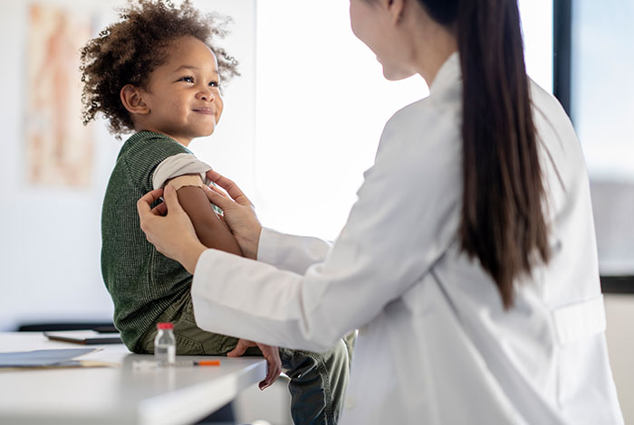 Pediatrician applying a bandage on child's arm