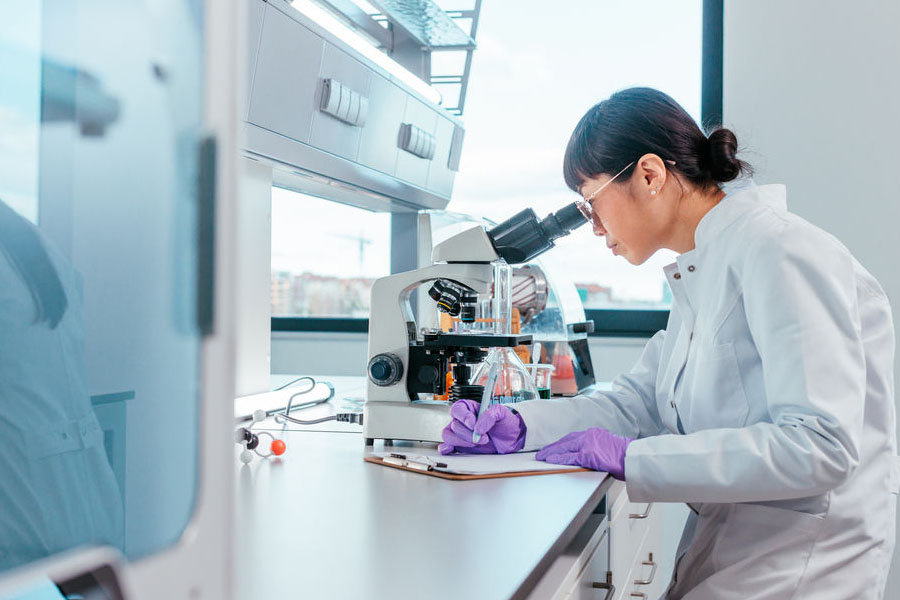 Scientist viewing samples under a microscope