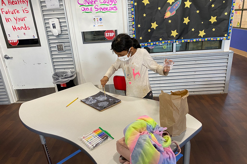 A girl coloring during an after-school program.