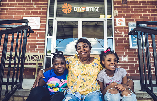 Family sitting in front of City of Refuge