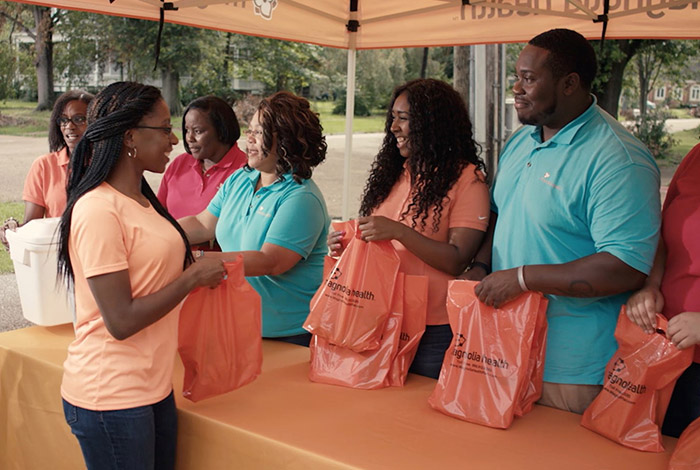 Volunteers handing out care packages at a community event booth