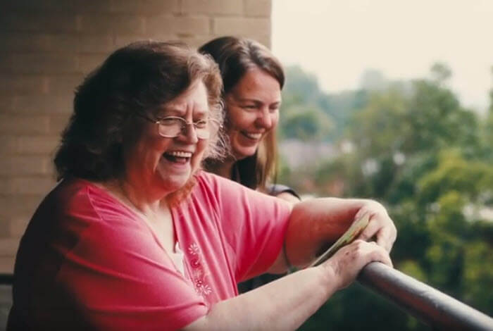 two women smiling on balcony