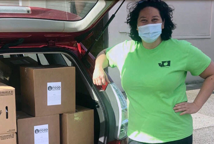 masked woman standing by trunk with donations