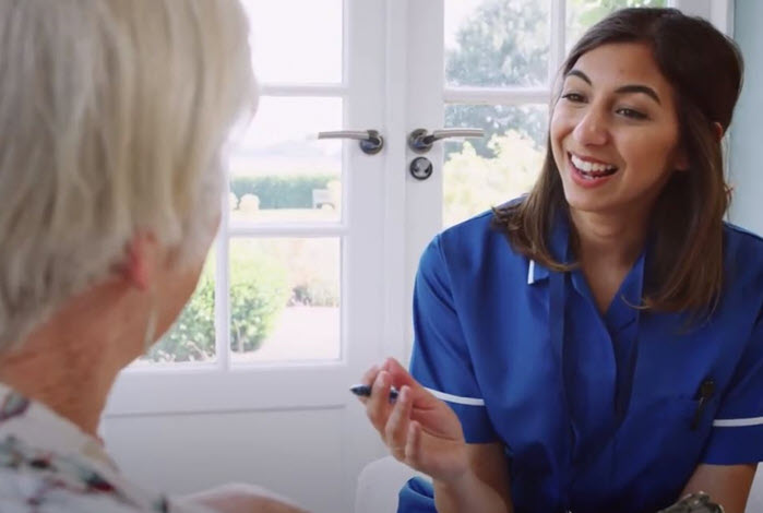 nurse talks with patient on couch