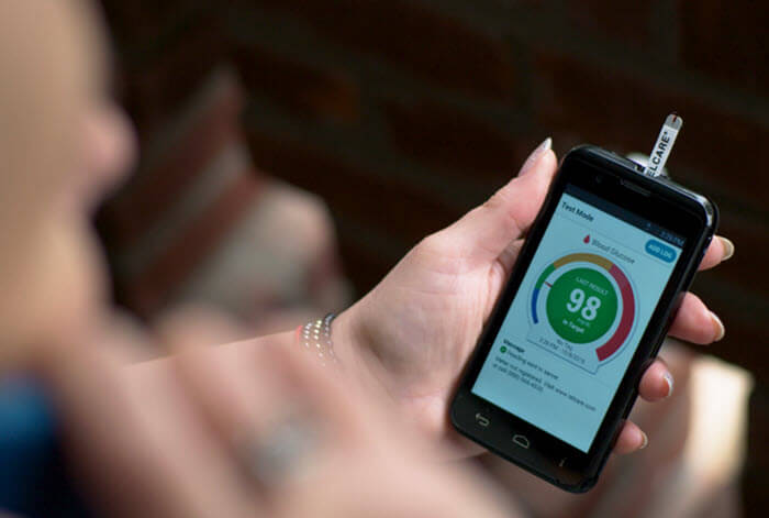 Person viewing diabetic information on mobile device