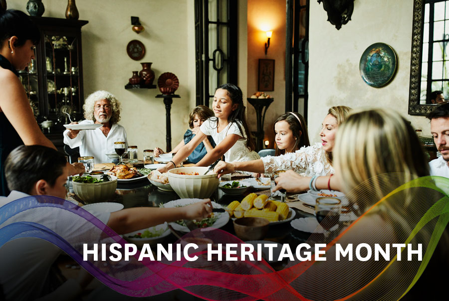Hispanic family at a dinner table serving food and eating