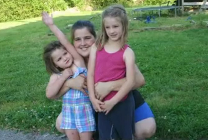 smiling family kneels on lawn