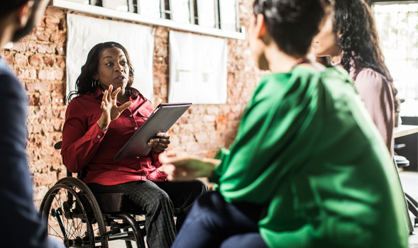 women in wheelchair talking to group