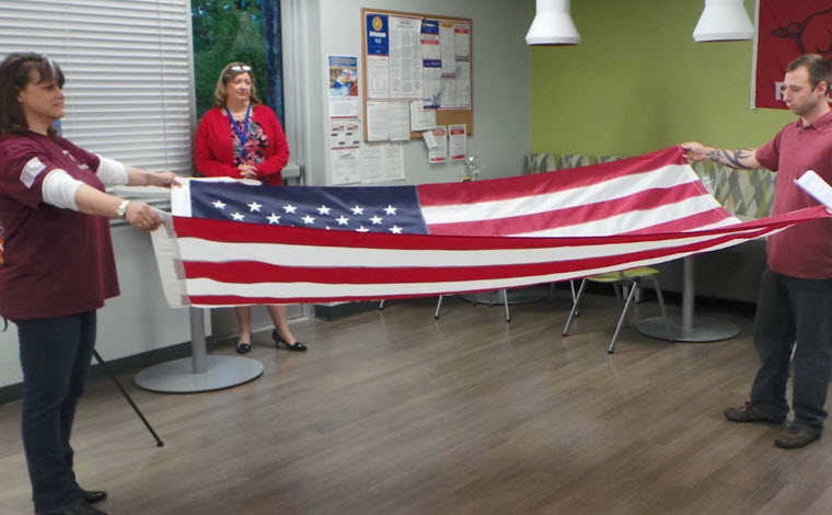 members of the military community participate in flag folding ceremony