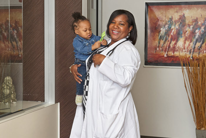 doctor holds young patient in office