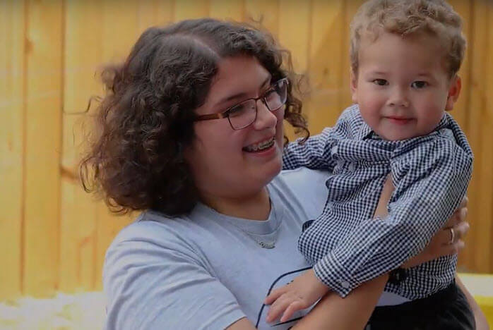 mother holds young smiling son