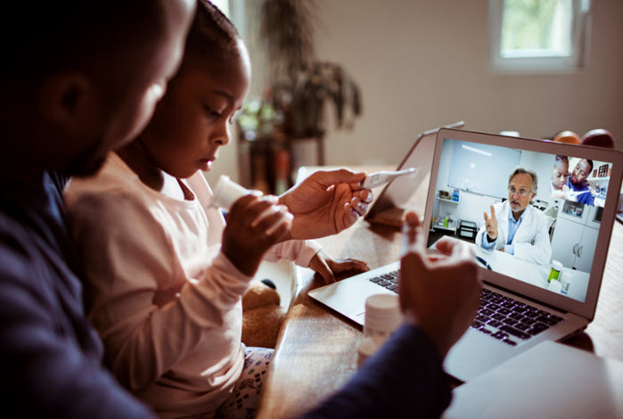 father and daughter participate in doctor's appointment via telehealth