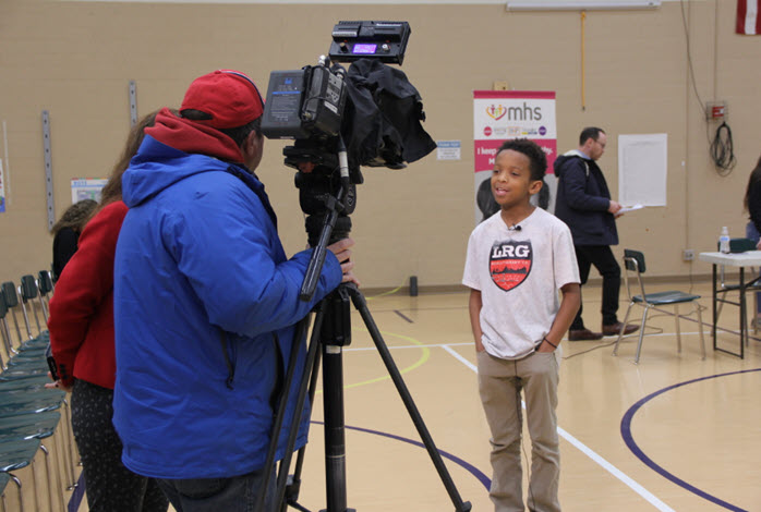 Kid at an interview during the No One Eats Alone event