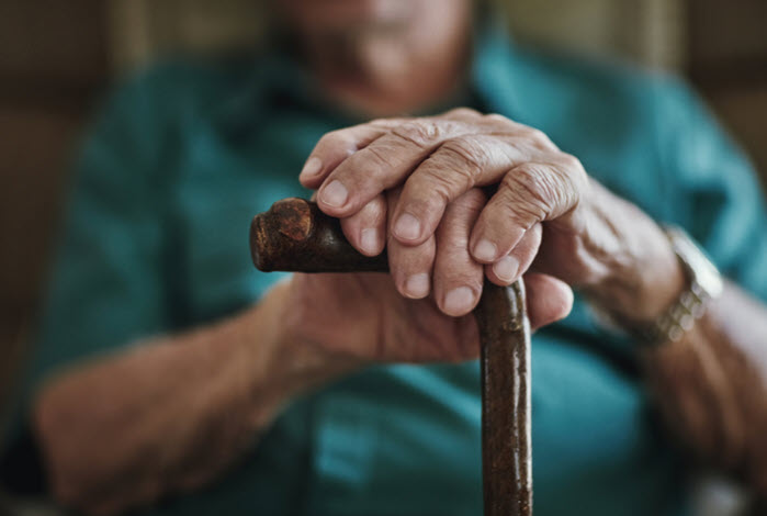old man holding cane with both hands