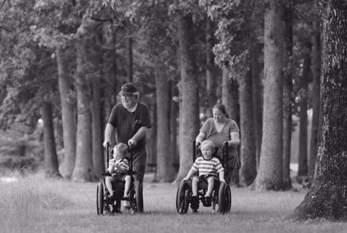 parents push children in wheelchairs
