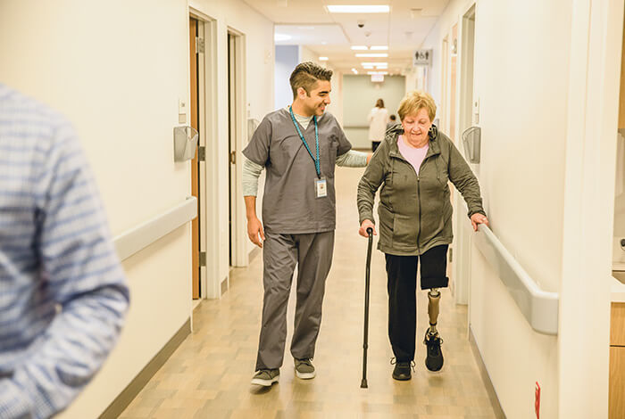 physician walking member down hospital hall