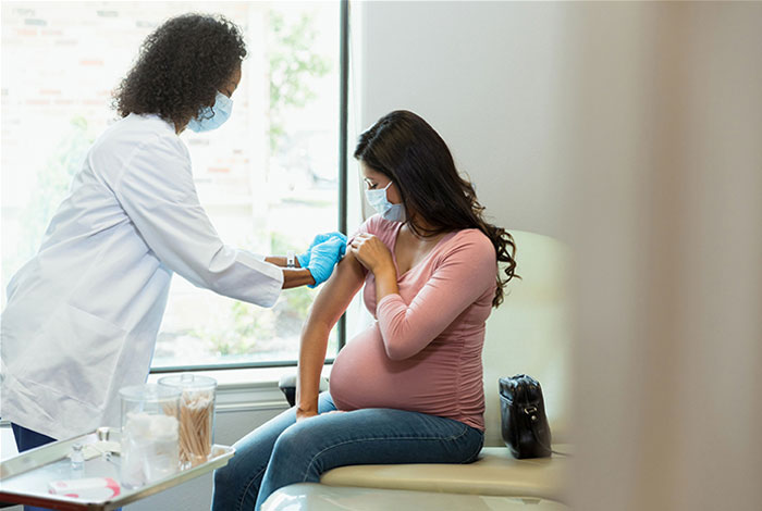 Pregnant woman getting vaccinated in doctor's office