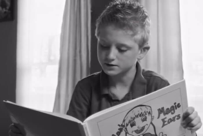 Young boy reading book at home