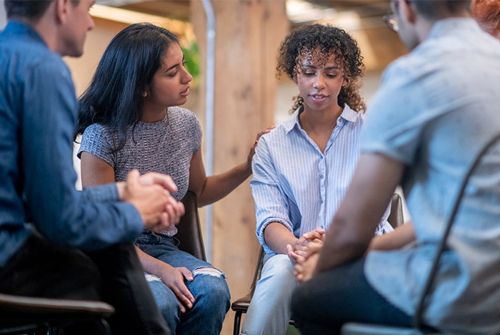 supportive friend comforts woman discussing a difficult topic