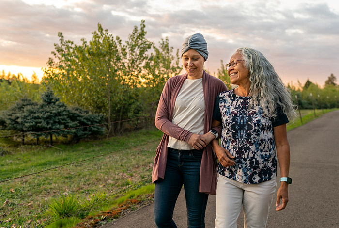 two women walking in the countryside arm in arm