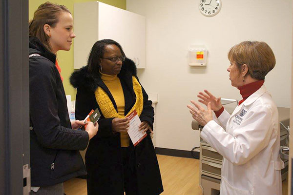 Healthcare provider talking to two visitors.