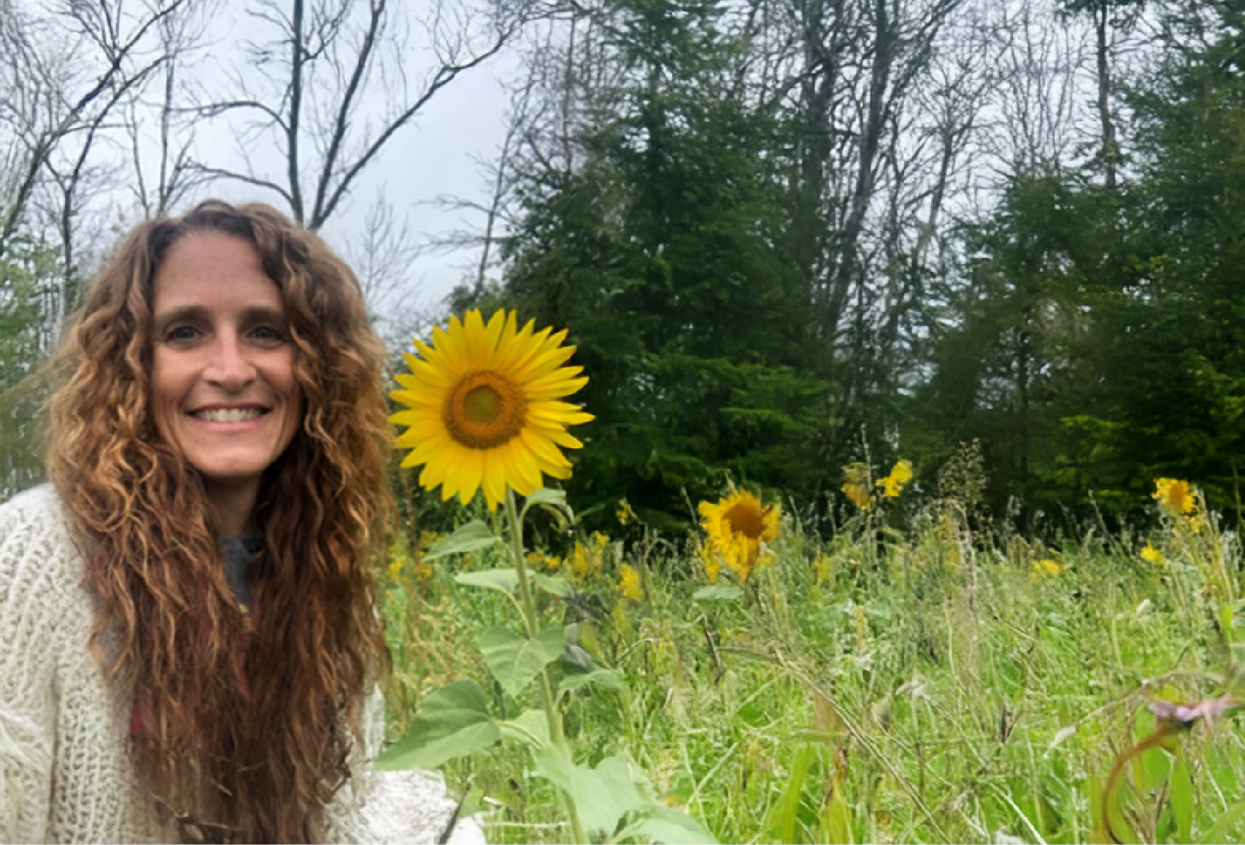 woman in front of sunflower field smiling