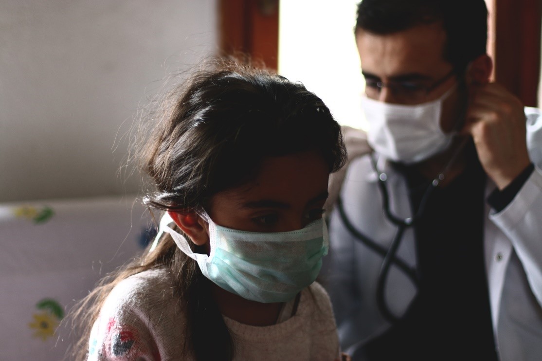 young girl patient and doctor wearing masks during a checkup