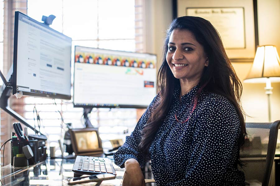 Nurse Advice Line team member working at a computer with dual monitors and a headset in a non‑clinical workspace